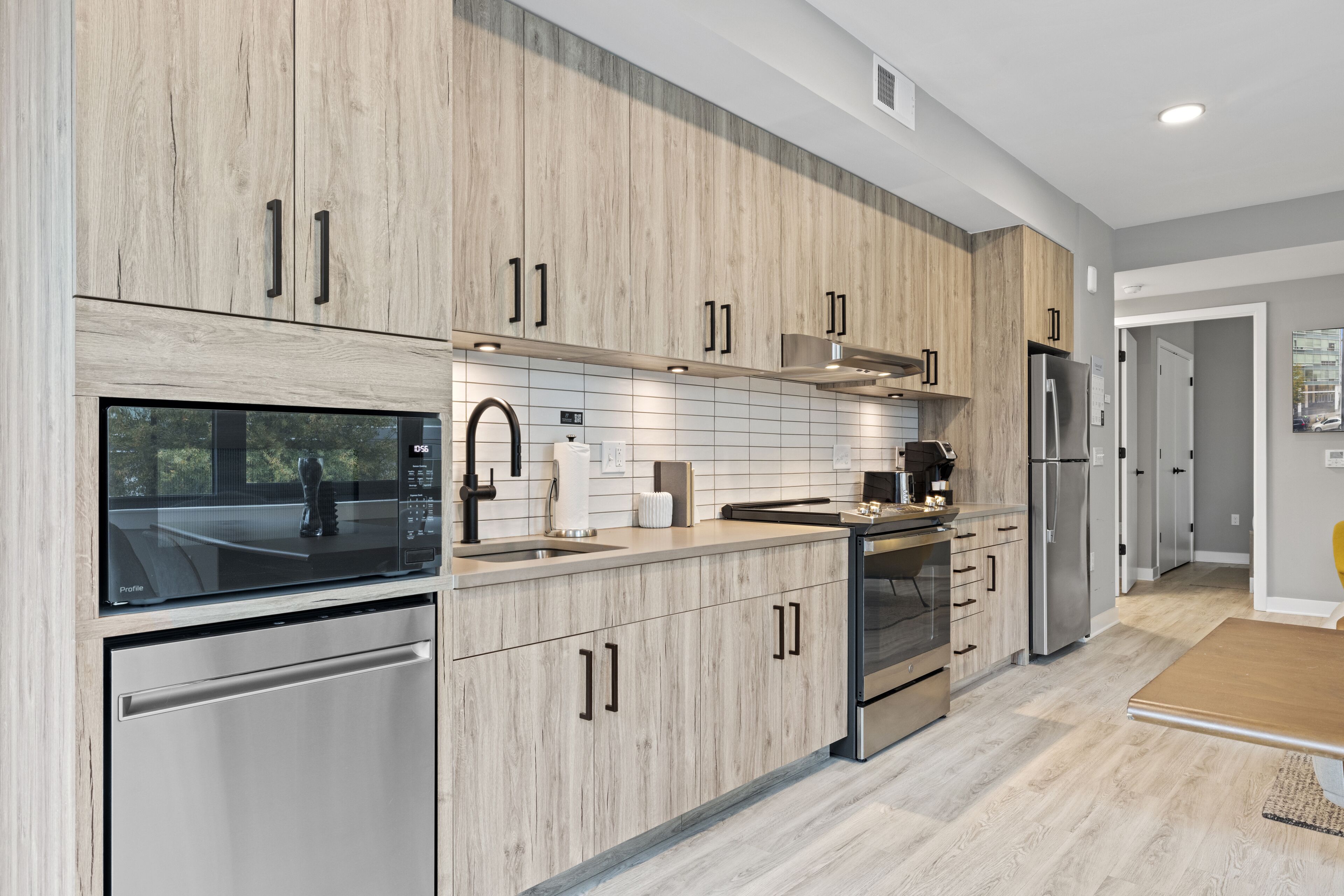 Una cocina moderna con armarios de madera, electrodomésticos de acero inoxidable y un ventanal amplio.