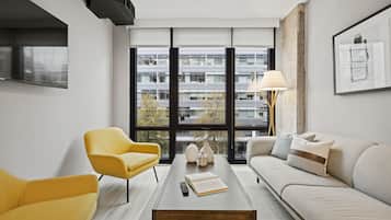 Una sala de estar moderna con un sofá, un sillón amarillo y una mesa de centro.
