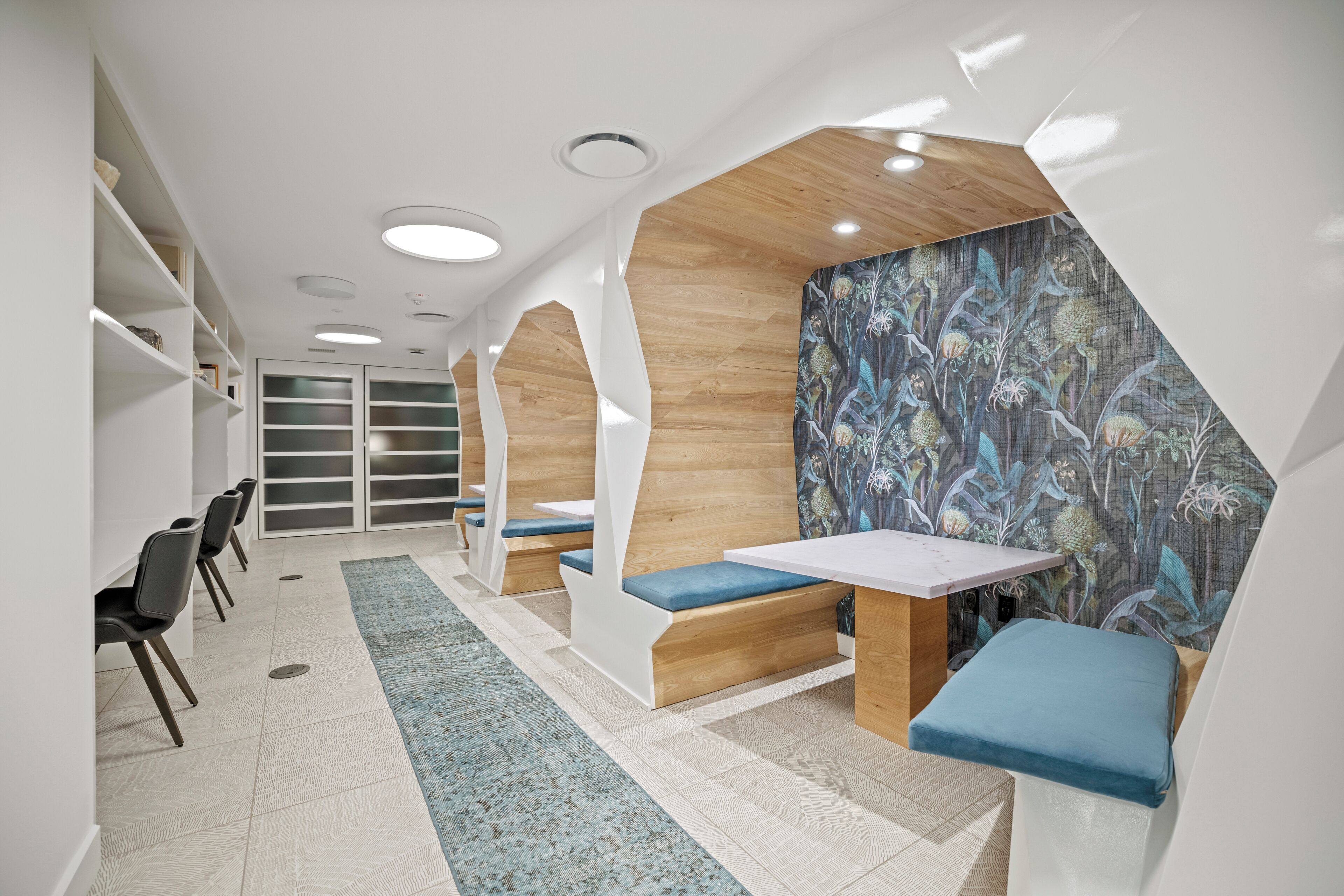 A modern interior with seating areas, a table, and a patterned wall.