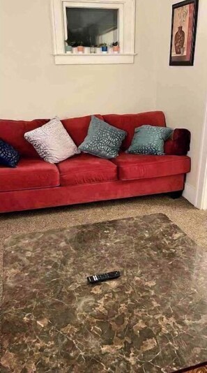 Relax in this stylish living room with a sofa, coffee table, and artwork.