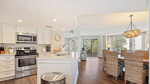 A modern kitchen with white cabinetry, stainless steel appliances, and a central island. - BEAUTIFULLY RENOVATED, OCEAN VIEW - VILLAMARE. PICKLEBALL-TENNIS INCLUDED.   (Hilton Head Island)