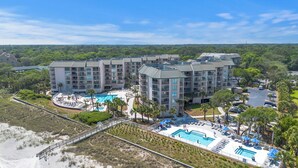 A resort with multiple buildings, a large central pool, and a beach area. - BEAUTIFULLY RENOVATED, OCEAN VIEW - VILLAMARE. PICKLEBALL-TENNIS INCLUDED.   (Hilton Head Island)