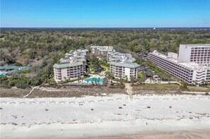 A resort with multiple buildings, a central pool, and a beach in the foreground. - BEAUTIFULLY RENOVATED, OCEAN VIEW - VILLAMARE. PICKLEBALL-TENNIS INCLUDED.   (Hilton Head Island)