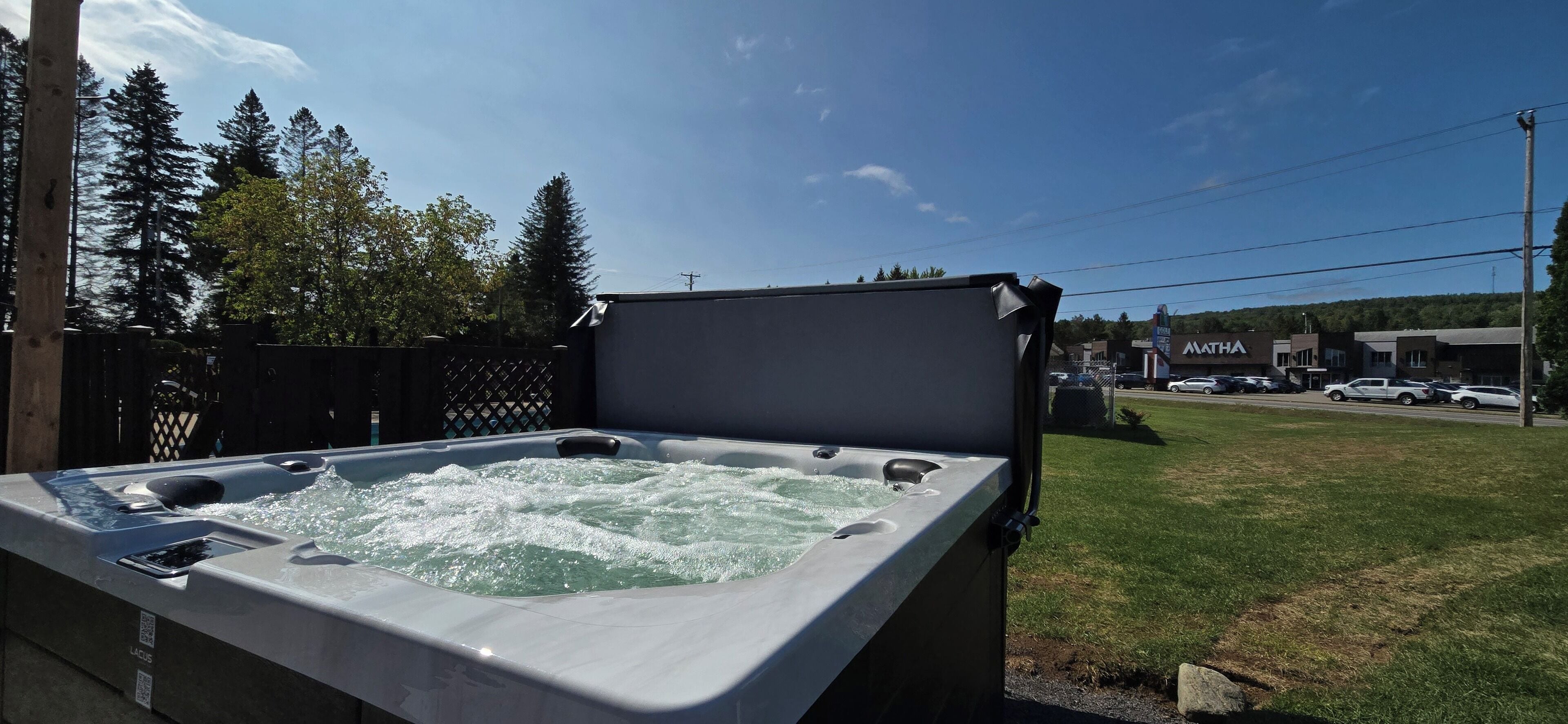 Un jacuzzi con vista a un estacionamiento y edificios al fondo.