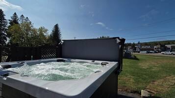 Un jacuzzi con vista a un estacionamiento y edificios al fondo.