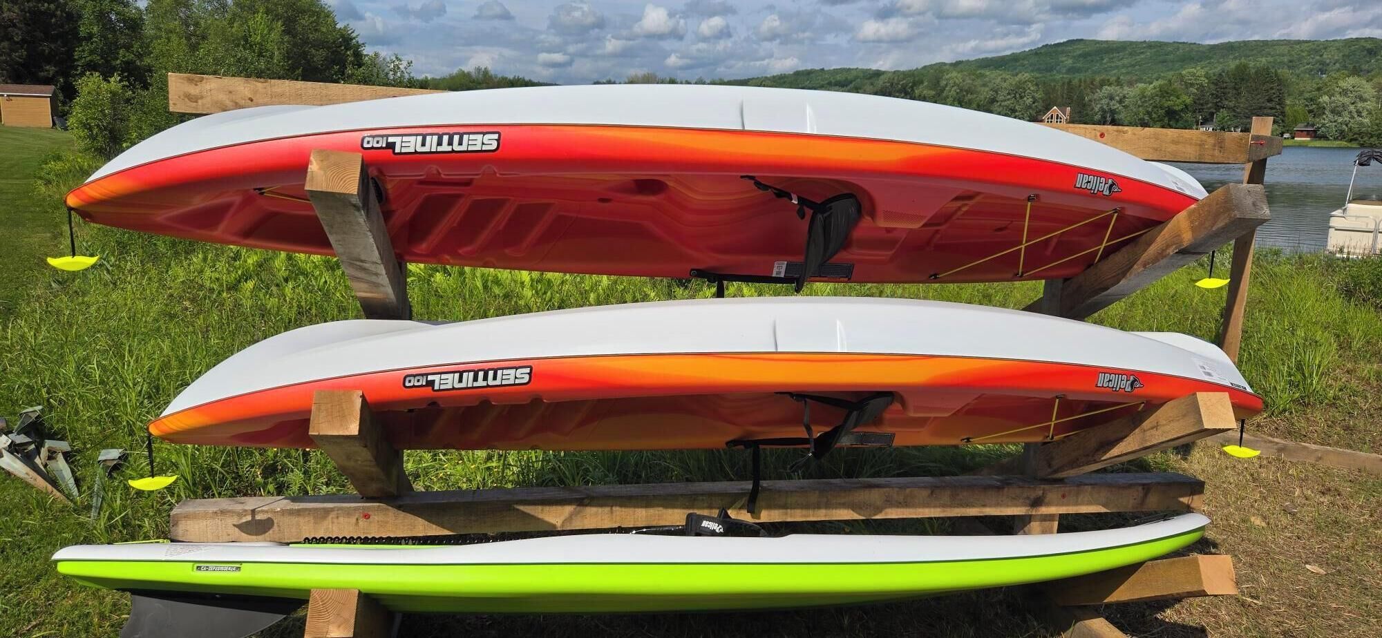 Two SUP boards on a wooden stand outdoors.