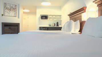 Une chambre d’hôtel équipée d’un lit, d’un four à micro-ondes, d’une machine à café et d’une petite plante.
