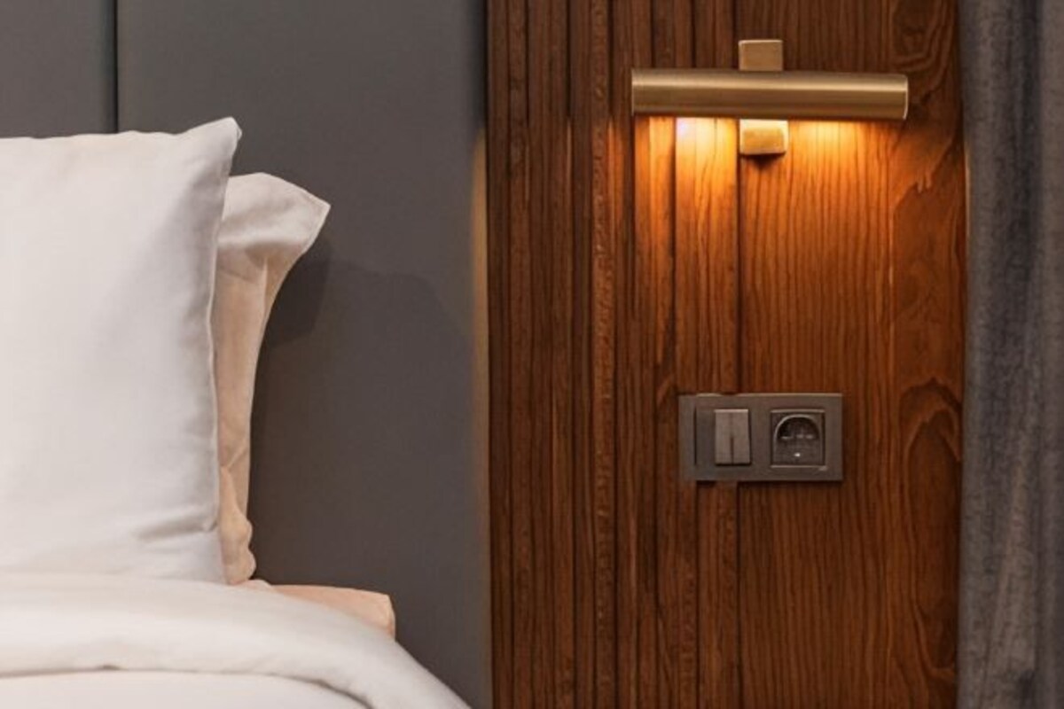 A wooden door with a light switch and a keyhole.