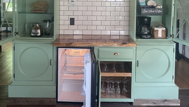 Una cocina con refrigerador empotrado, cafetera y microondas.