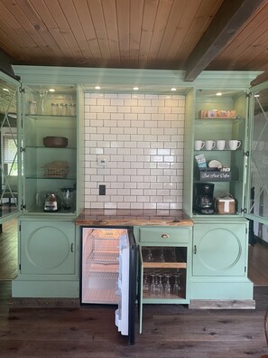 Una cocina con refrigerador empotrado, cafetera y microondas.