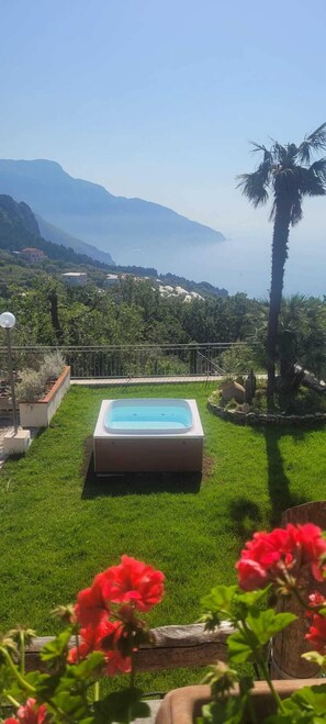 A swimming pool in a lush garden with a view of mountains and the sea. - Villa Cristina (Piano di Sorrento)