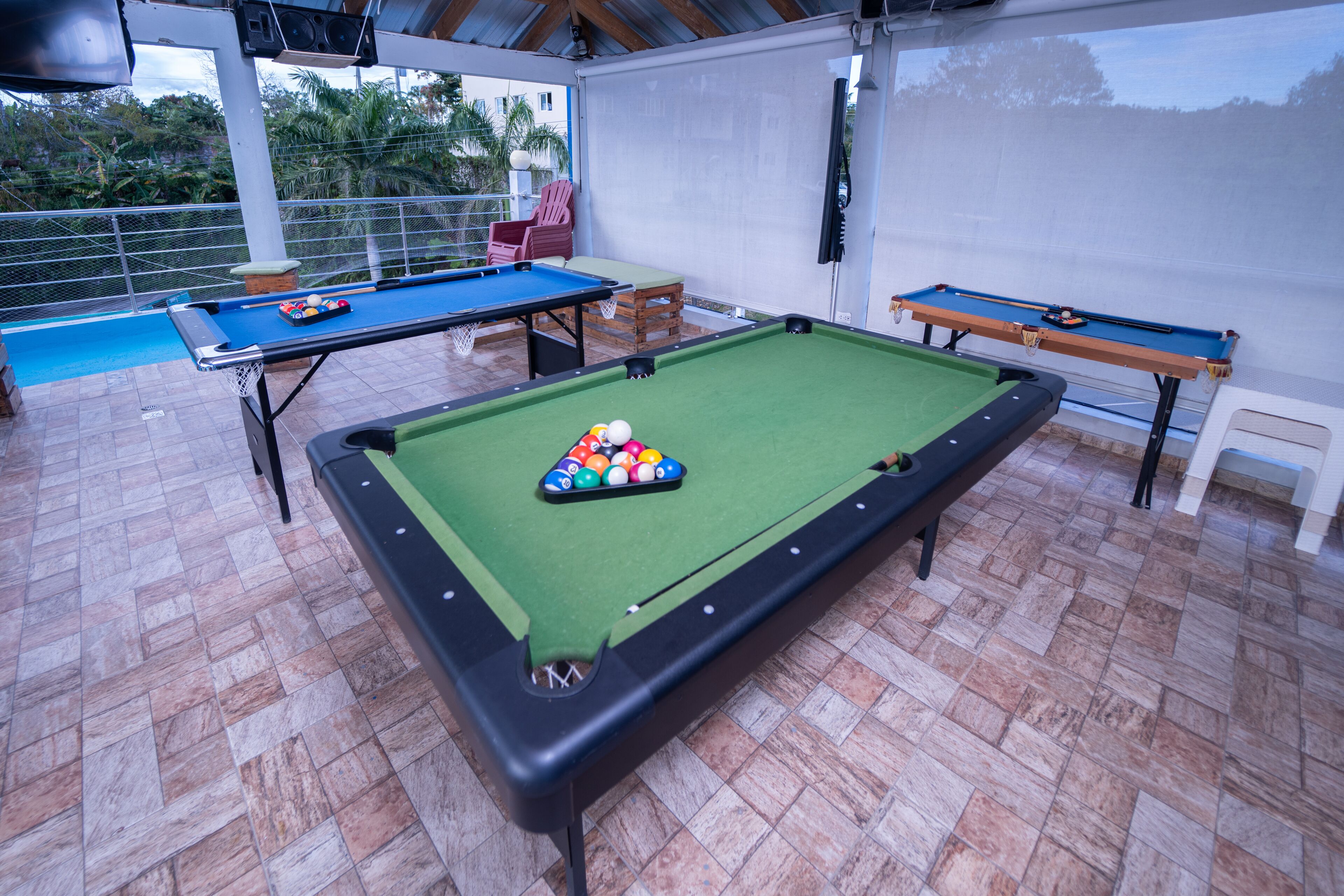 Une table de billard recouverte d’un drap vert, un queue de billard et un jeu de billes.