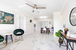 Interior moderno com área de refeições, ventilador de teto e um mapa-múndi na parede.