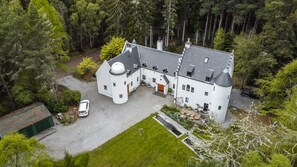 A large, white, multi-story building with a symmetrical design, a central courtyard, and a small annex. - White Rose Tower (Invergordon)