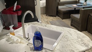A compact kitchenette with a sink, a red appliance, and a bottle of dish soap. - Posh Mountain Camping w/ 120" Screen Theater ·Hot-Tub · Firepit · Hiking Trails (Jonesville)