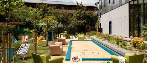 A courtyard with outdoor seating, a pool, and a building in the background.
