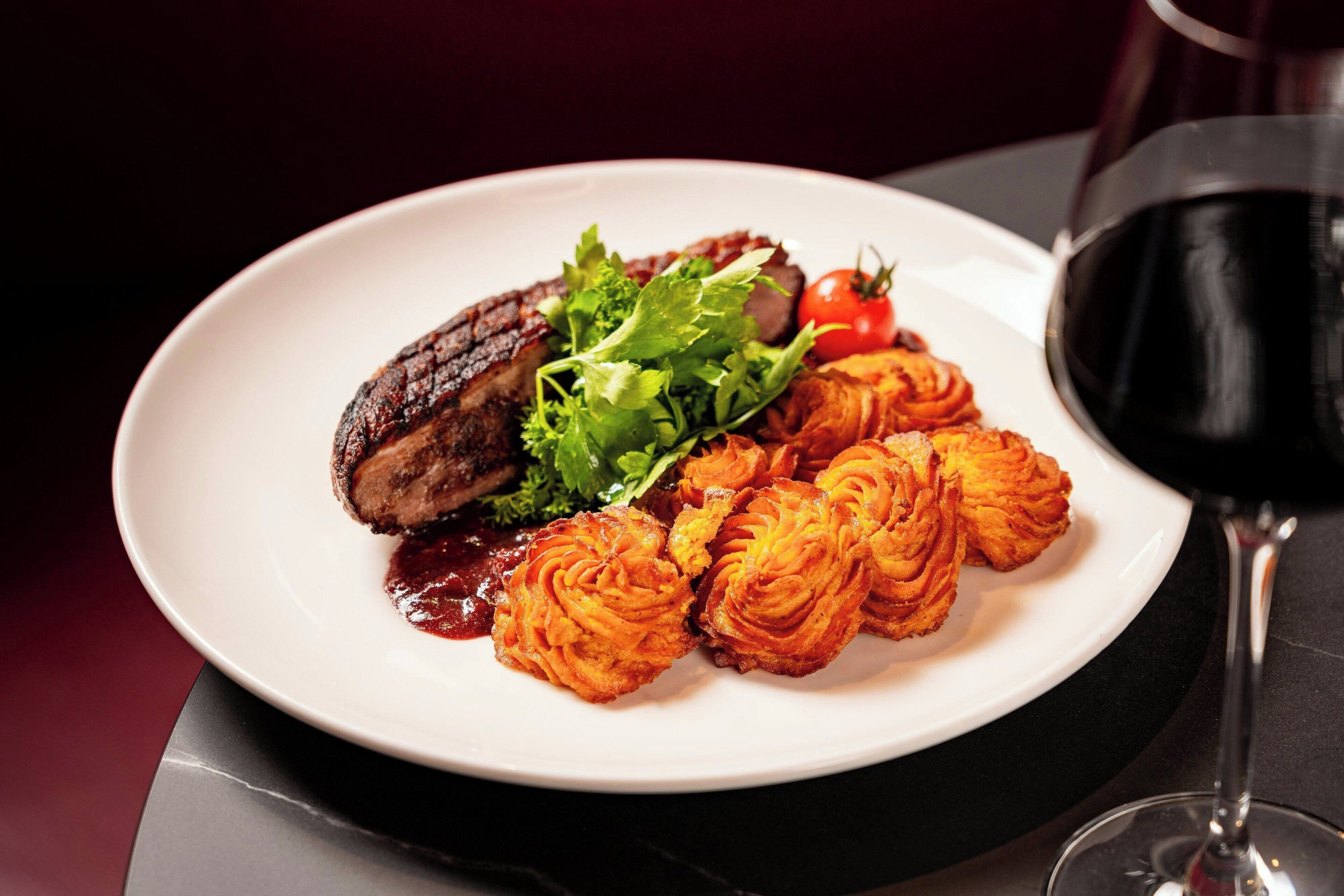 A plate of food with a glass of red wine.