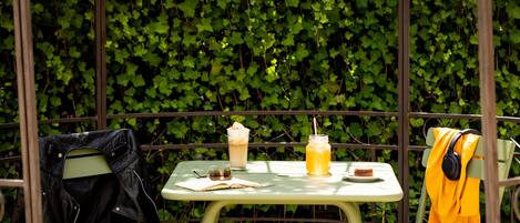 A table with a drink, a book, and headphones.