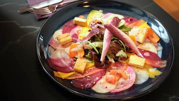 Un plato de ensalada colorida con diferentes verduras y cubos de tofu.