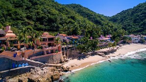 Une station balnéaire dotée de villas, d’une plage et bordée de montagnes.