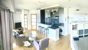 A modern apartment with a kitchen, dining area, and living room. - Grand Studio Avec Terrasse et vue mer (Saint-Laurent-du-Var)