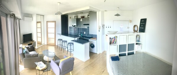 A modern apartment with a kitchen, dining area, and living room.