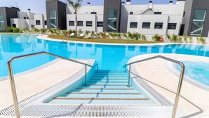 Ein Pool mit Stufen, umgeben von modernen Gebäuden mit großen Fenstern.