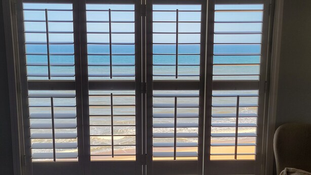 Una habitación con un ventanal grande con vistas a la playa.