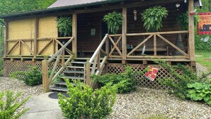 A rustic cabin with a wooden exterior, a porch with steps, and a sign that reads "WELCOME". - Welcome to our peaceful, rustic cabin in the Hocking Hills Area (Wellston)