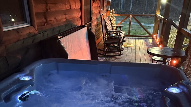 A hot tub with a wooden deck and outdoor seating. - Welcome to our peaceful, rustic cabin in the Hocking Hills Area (Wellston)