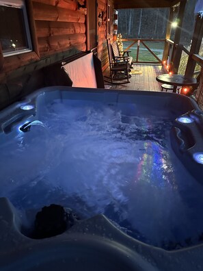 A hot tub with a wooden deck and outdoor seating. - Welcome to our peaceful, rustic cabin in the Hocking Hills Area (Wellston)