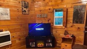 A wooden cabin interior with a television, fireplace, and a sign that reads "BEAR". - Welcome to our peaceful, rustic cabin in the Hocking Hills Area (Wellston)