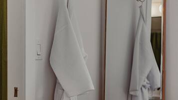 A bathroom with a large mirror, a towel rack, and a towel hanging on it.