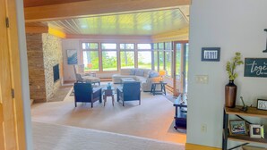 A spacious living area with a stone wall, large windows, and a view of the outdoors.
