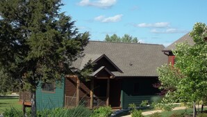 A rustic cabin with a sloped roof, a wooden porch, and a small deck. - Beautiful Cabin - Secluded But Convenient (Branson)
