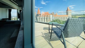 Un balcon donnant sur un château, avec une table et une chaise.