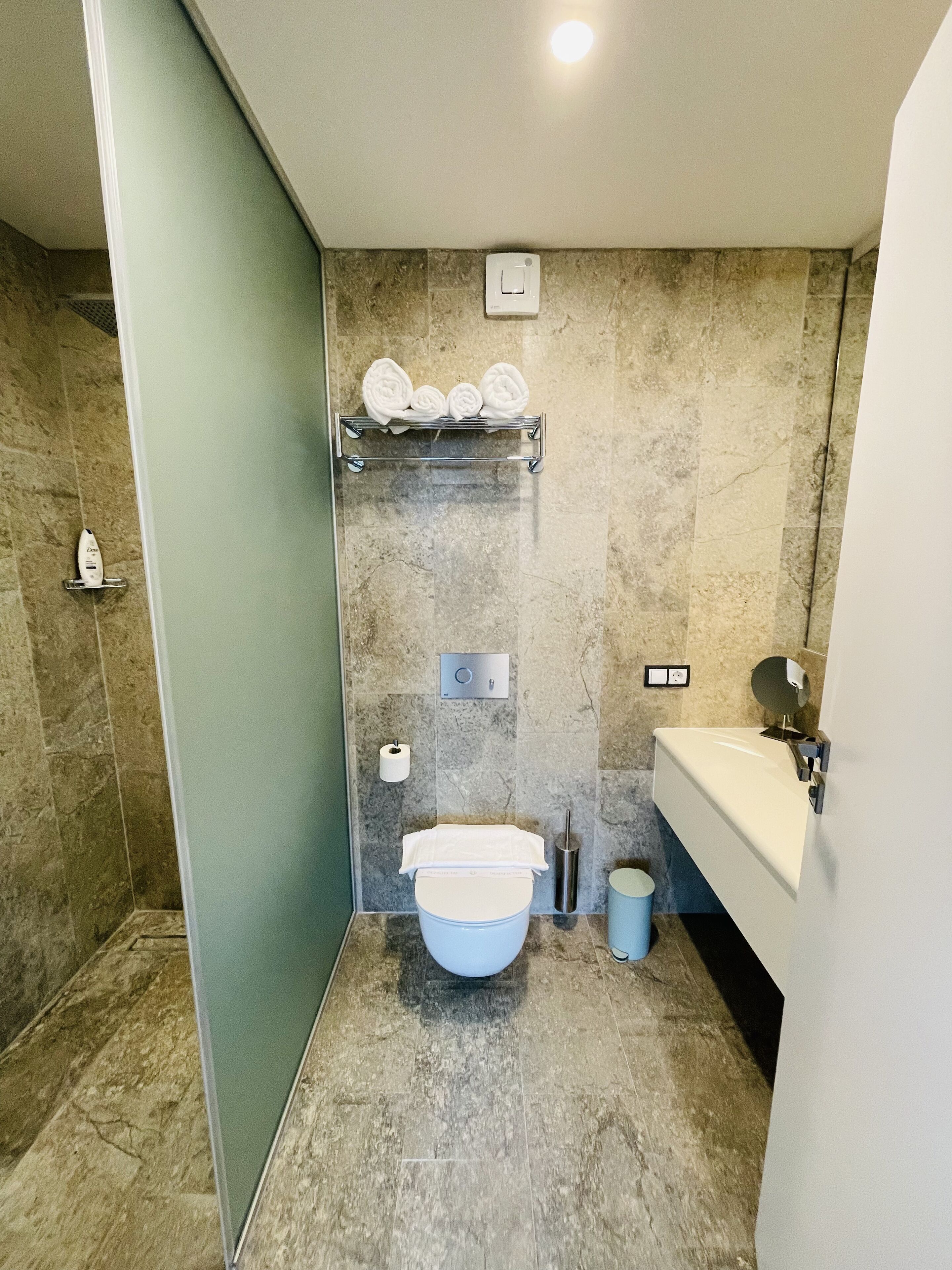 Een moderne badkamer met toilet, wastafel en douchehoek.