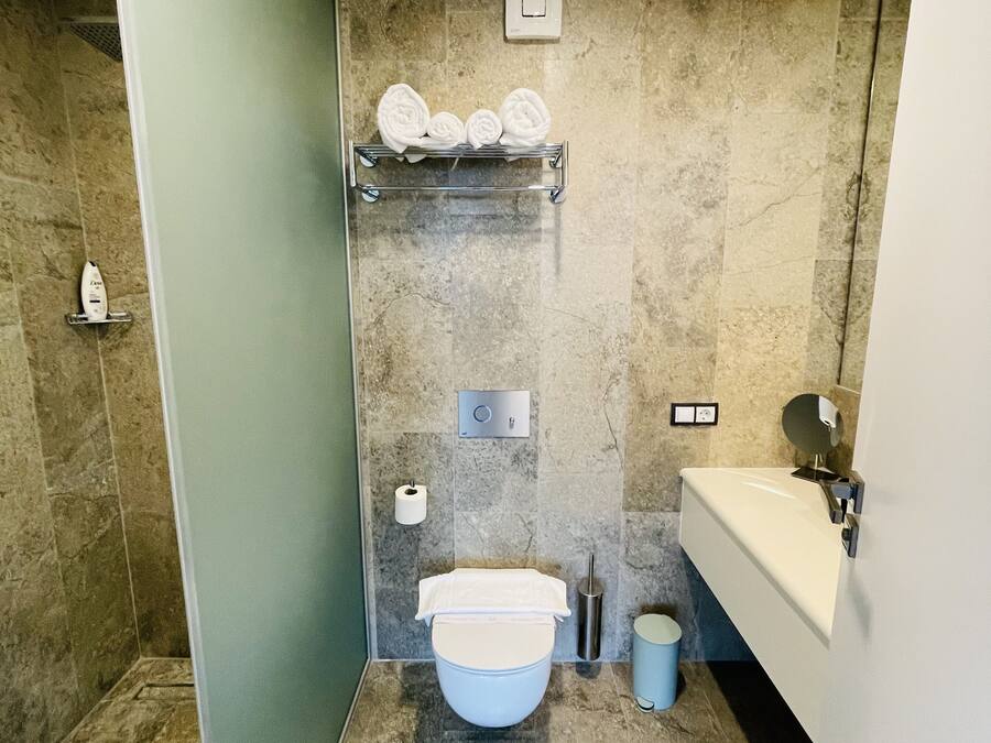 Een moderne badkamer met toilet, wastafel en douchehoek.
