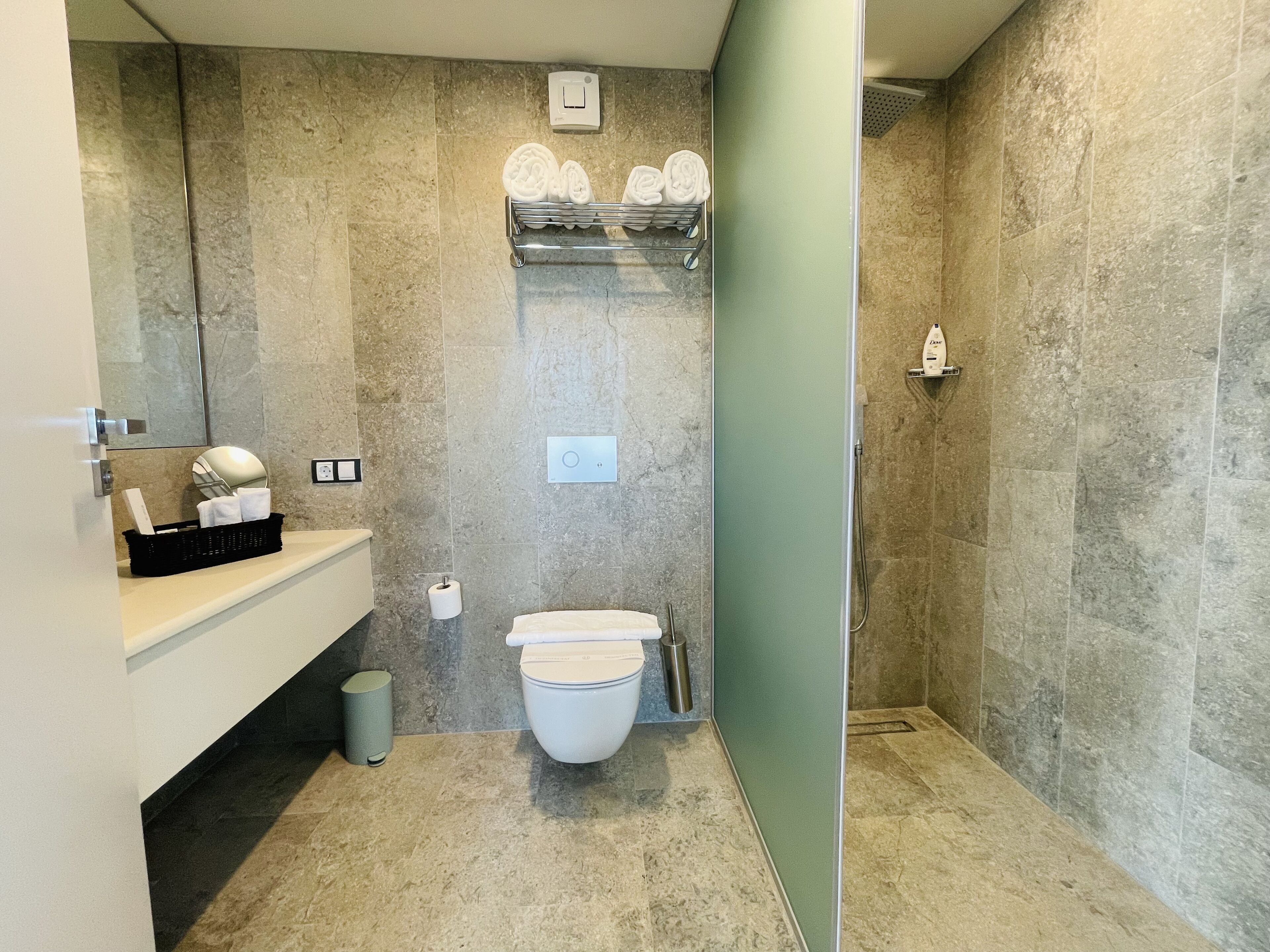 Een moderne badkamer met toilet, wastafel en douchehoek.
