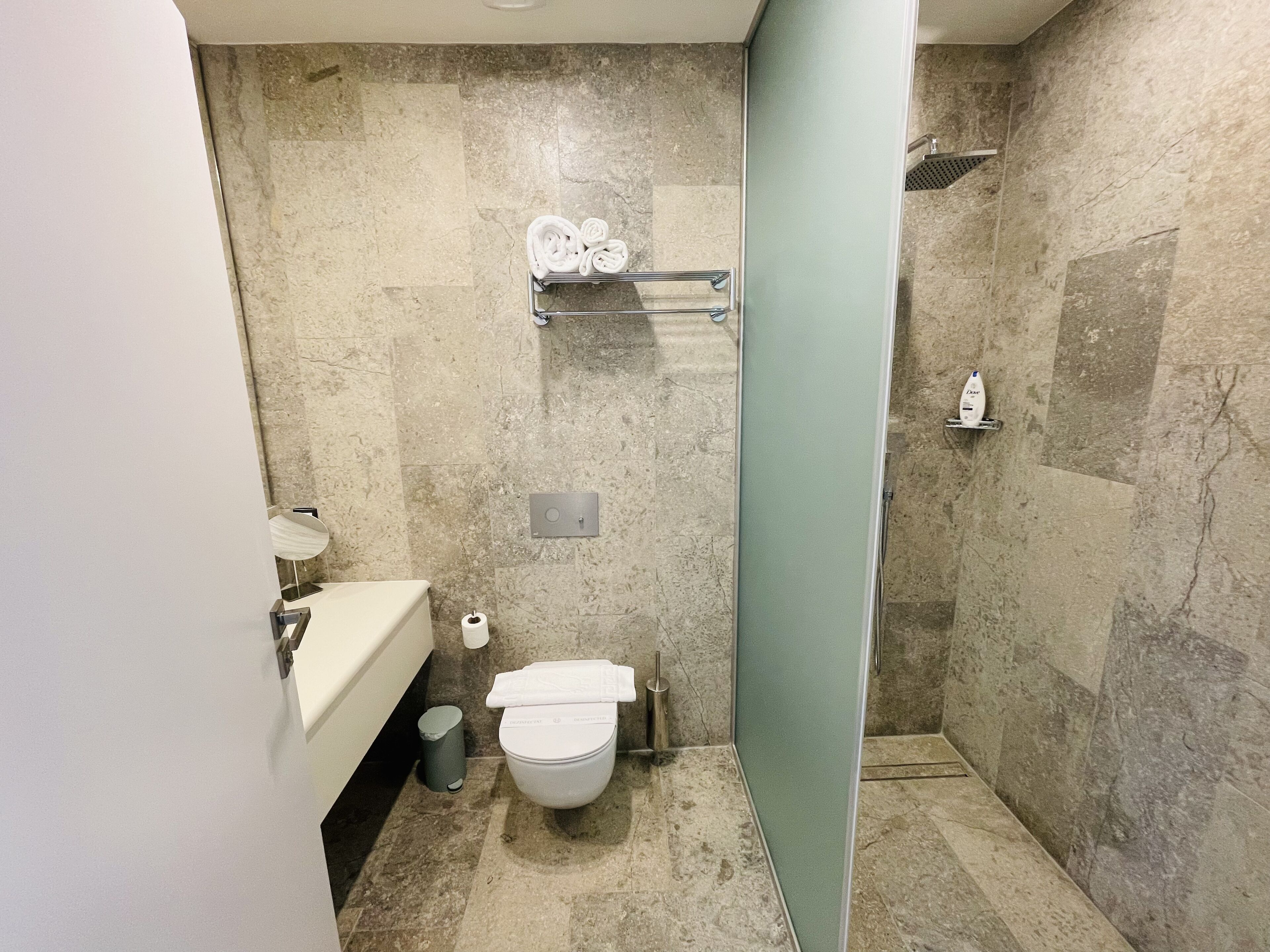 A bathroom with a toilet, sink, and shower area.