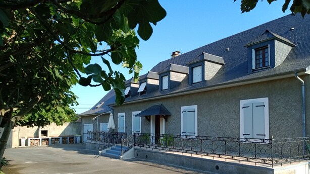Ein zweistöckiges Haus mit Balkon, Garage und Auffahrt.