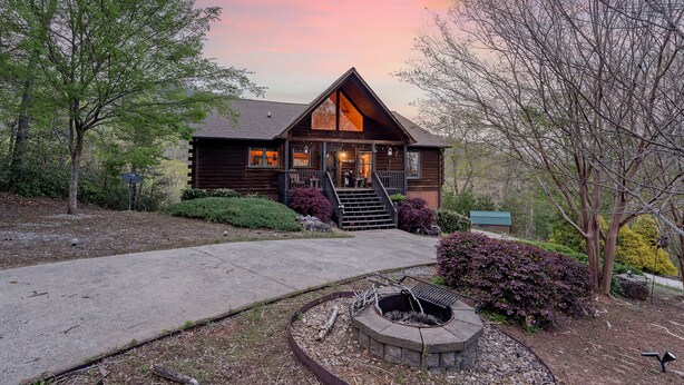 A log cabin with a large front porch, a fire pit, and a well-maintained garden. - Lake Lure Family Escape | Sleeps 10 | Bunk Room | Hot Tub | Near Chimney Rock (Lake Lure)