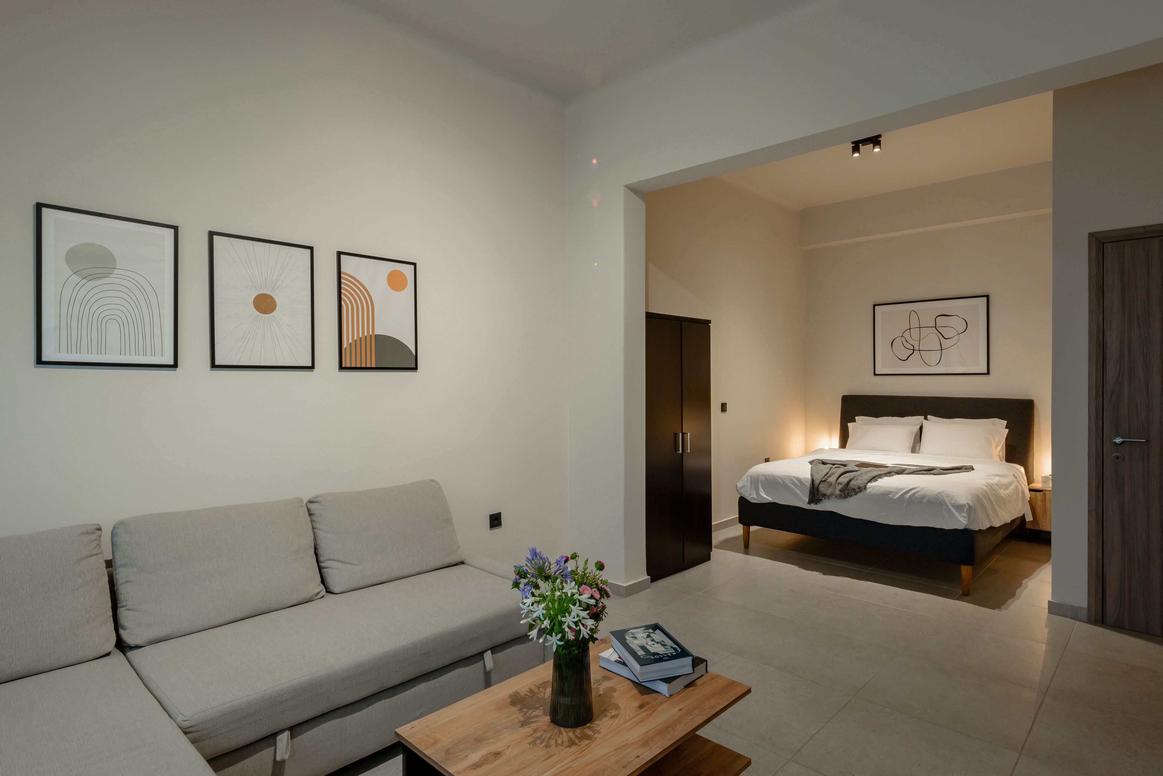 A modern room with a sofa, a bed, and artwork on the walls.