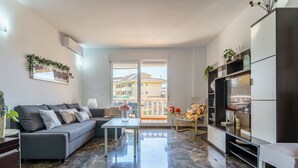 Un salon moderne avec un canapé gris, une table basse et un meuble TV doté d’étagères.