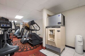 A gym with treadmills, a stationary bike, and a water dispenser.