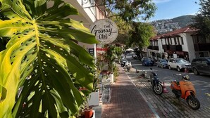 A street view with a building featuring a sign that reads "Hotel Tinay." - Nest Gunay Otel (Kas)