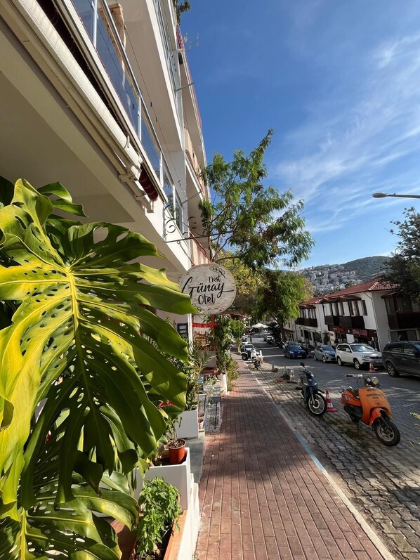 A street view with a building featuring a sign that reads "Hotel Tinay." - Nest Gunay Otel (Kas)