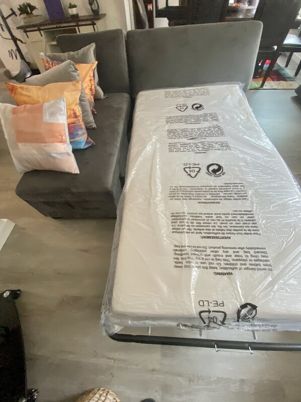 Un materasso in negozio, protetto da pellicola di plastica.