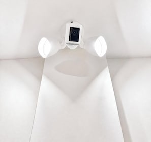 A ceiling-mounted security camera with a light fixture.