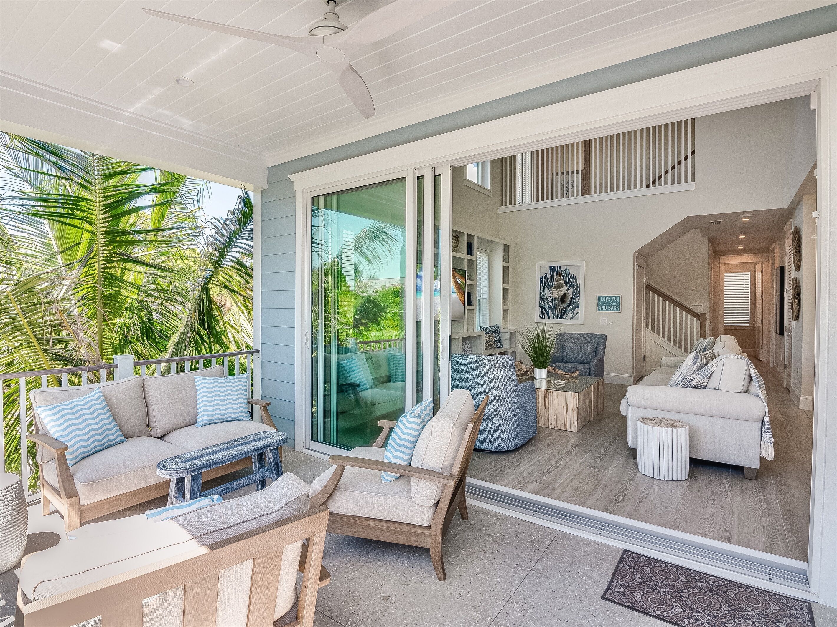 A spacious living area with a sliding glass door leading to a balcony, furnished with sofas and a coffee table.